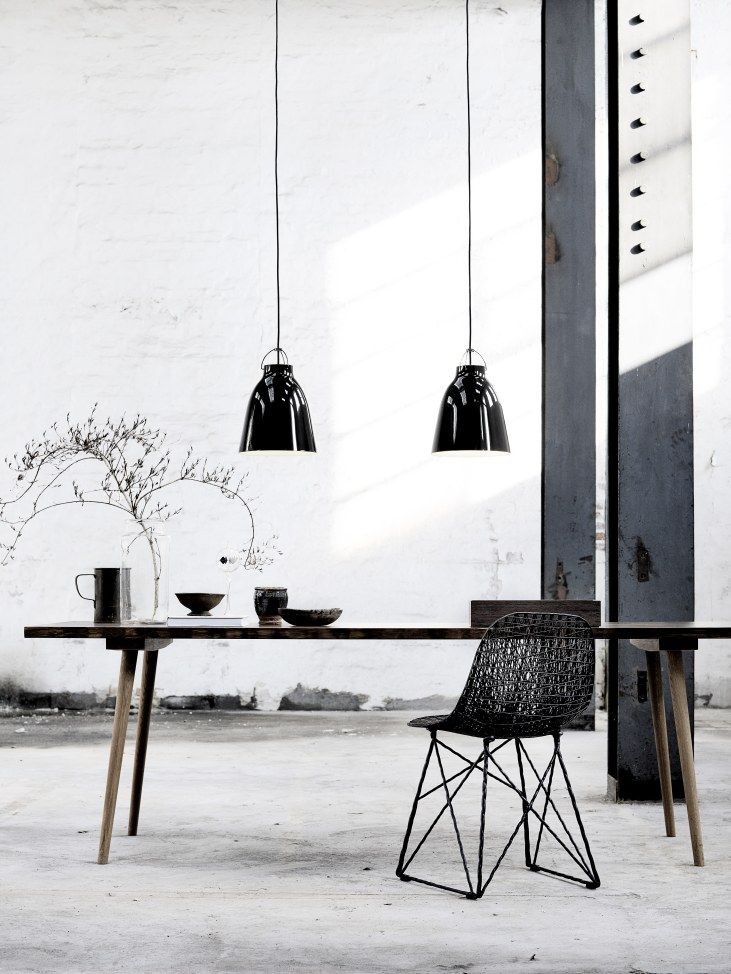 Zwei schwarze Caravaggio Pendelleuchten von Fritz Hansen über Esstisch, moderne Innenraumbeleuchtung.