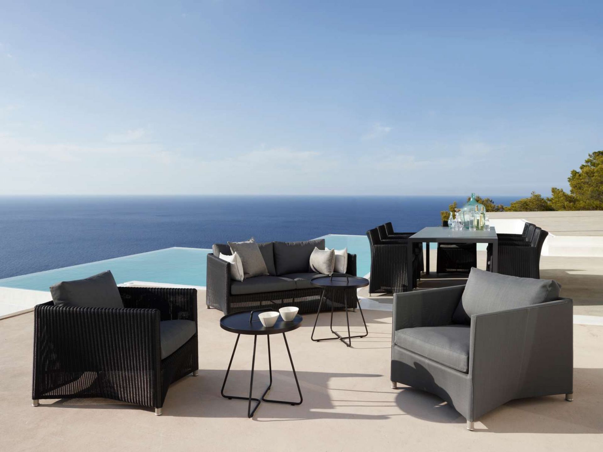 Cane-Line Diamond Outdoor Sofa 2-Sitzer und Loungemöbel auf Terrasse mit Meerblick. Gartenmöbel aus Rattan.