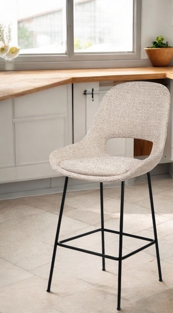 Theia Counter Armchair Low Barhocker von Freifrau Manufaktur mit beigem Stoffbezug und schwarzem Metallgestell.