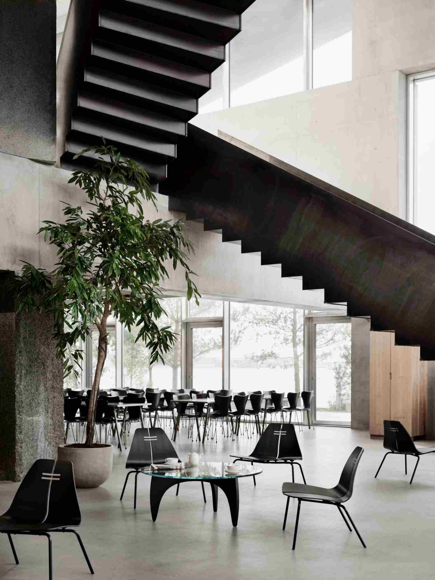 Innenaufnahme mit PK23 Loungesessel von Fritz Hansen, schwarzem Design und minimalistischem Interieur.