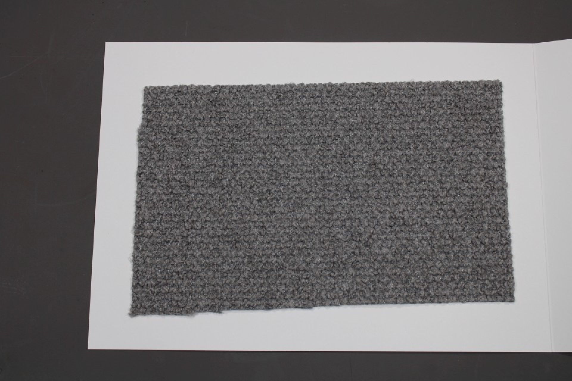 Stoffmusterkarte Cor Gruppe 82: Grauer, strukturierter Möbelstoff als Stoffprobe auf weißem Karton.