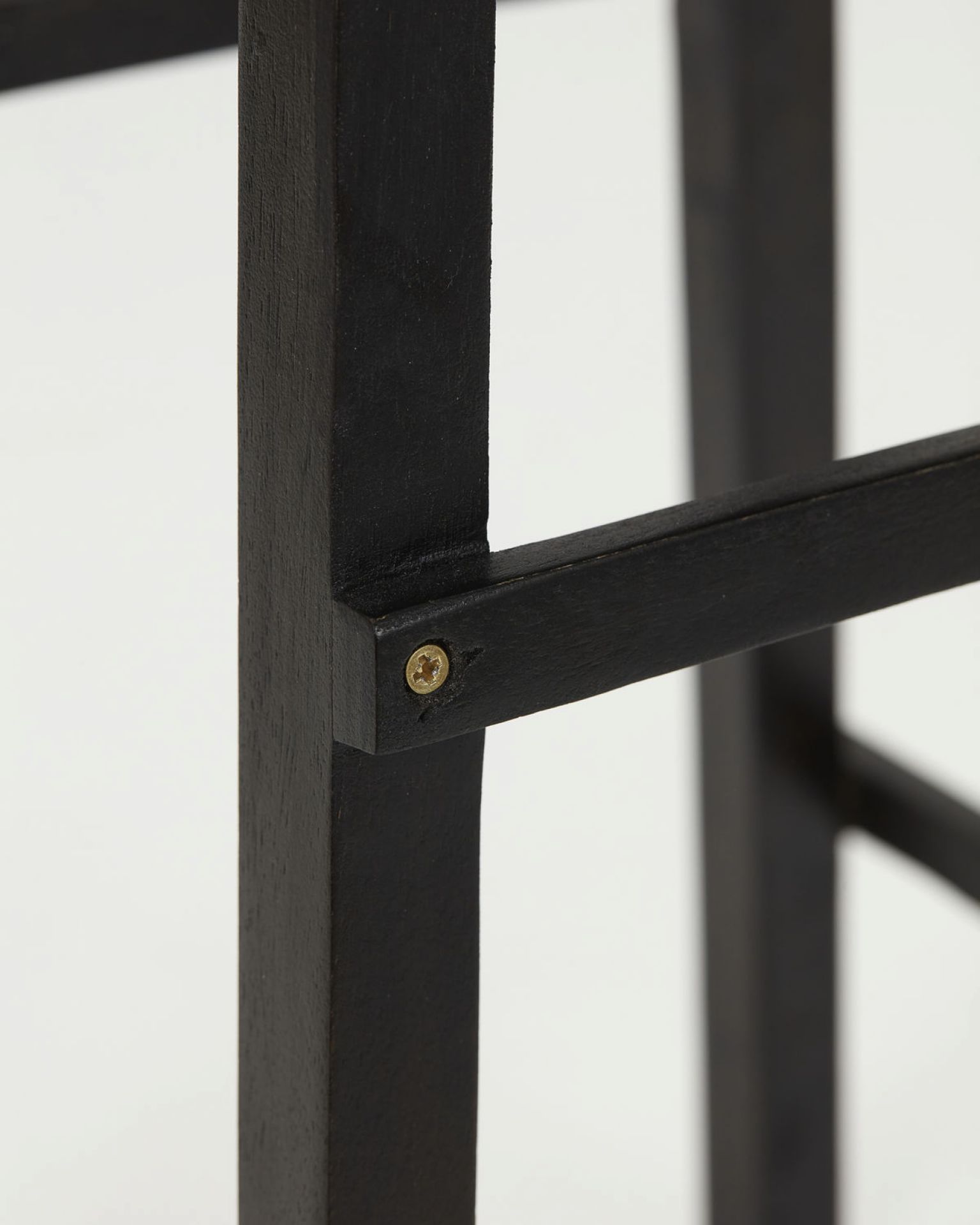 Detailaufnahme vom Laddi Beistelltisch in Schwarz, zeigt die Holzstruktur und Schraubverbindungen des Möbelstücks.