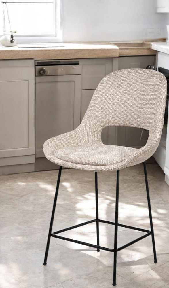 Theia Kitchen Armchair Barstool von Freifrau Manufaktur, niedriger Barhocker mit beigem Stoffbezug und schwarzem Metallgestell.