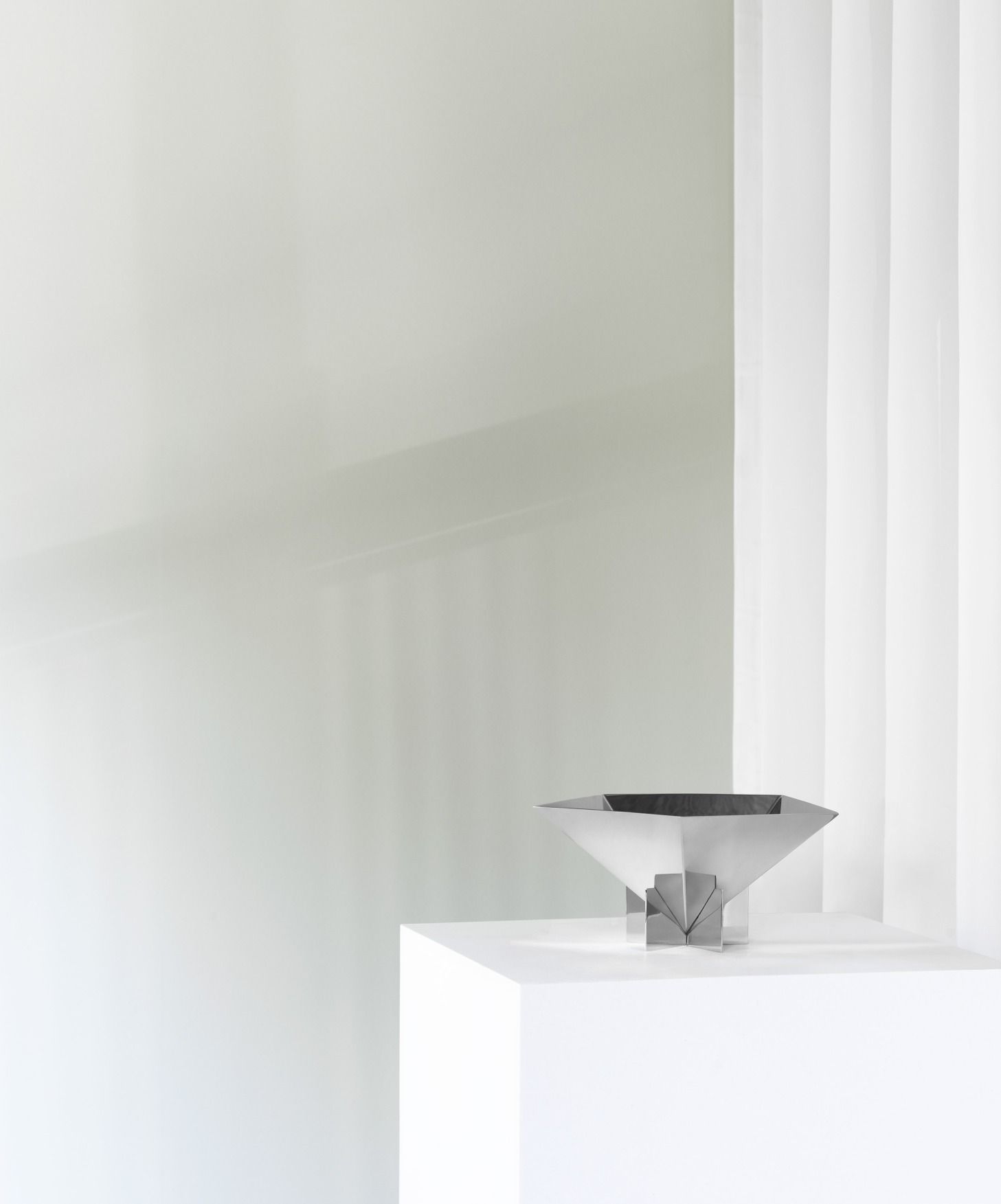 Nahaufnahme der Fem Schale von Normann Copenhagen aus Edelstahl auf weißem Sockel.