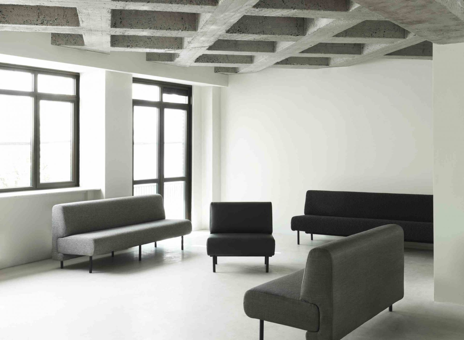 Helles Interieur mit grauem Fram Sofa von Normann Copenhagen und schwarzen Sofas.