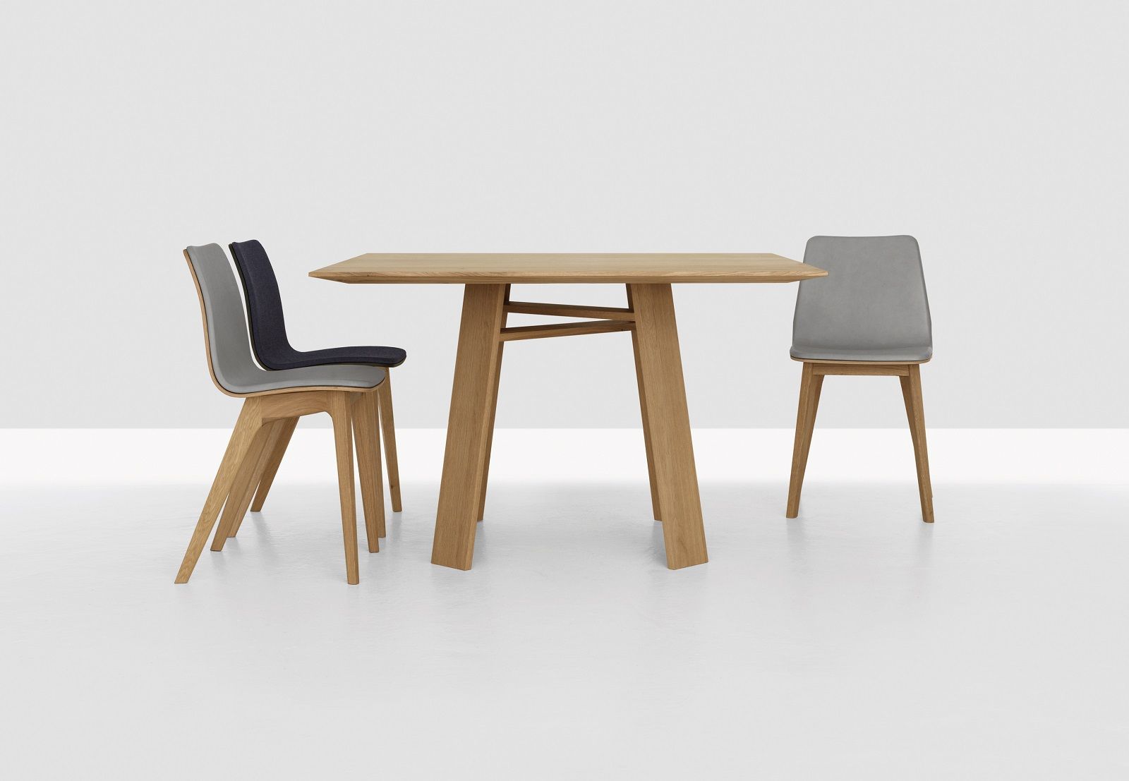 BONDT Tisch quadratisch Zeitraum aus hellem Holz mit zwei Stühlen vor weißem Hintergrund.