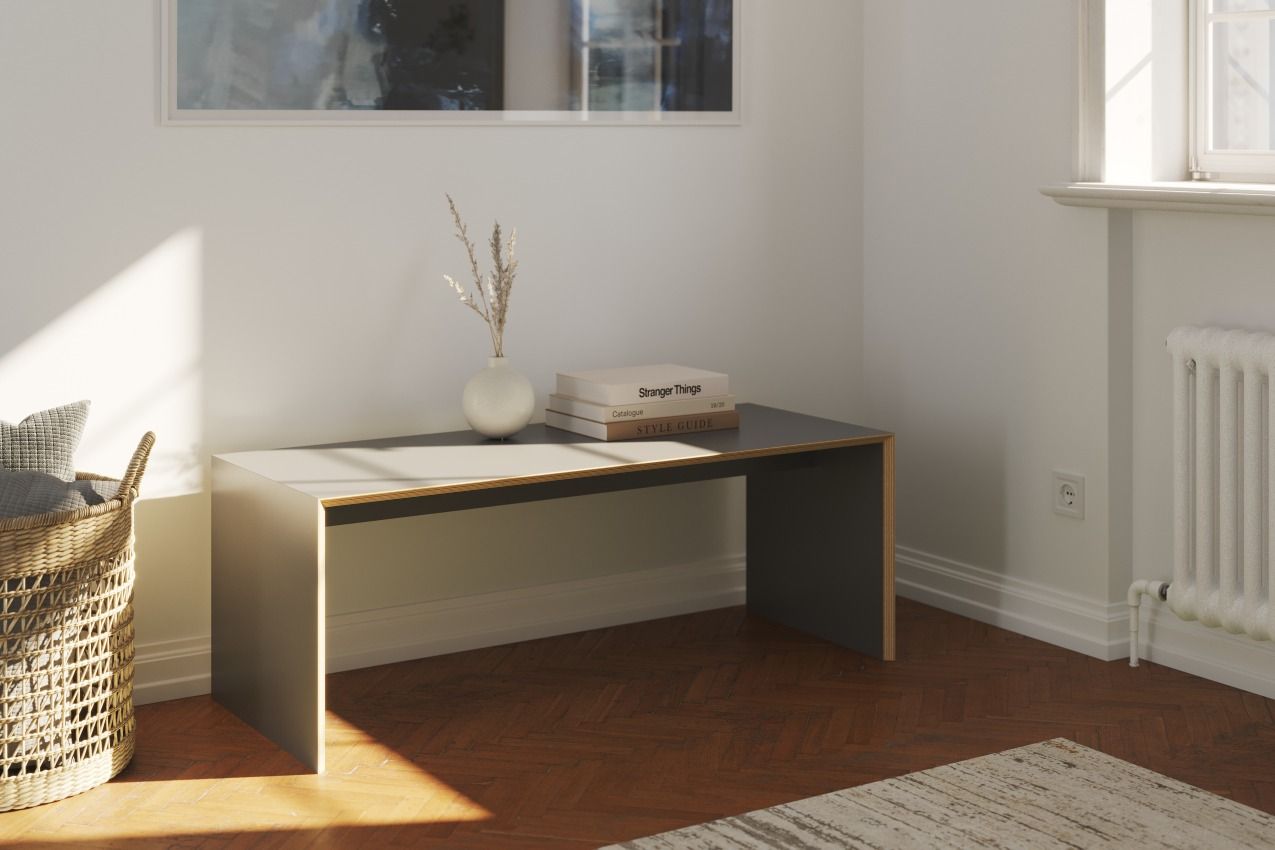 Müller Möbelwerkstätten Bridge Sitzbank/Beistelltisch in Grau mit Deko-Elementen im hellen Raum. Modernes Möbeldesign.