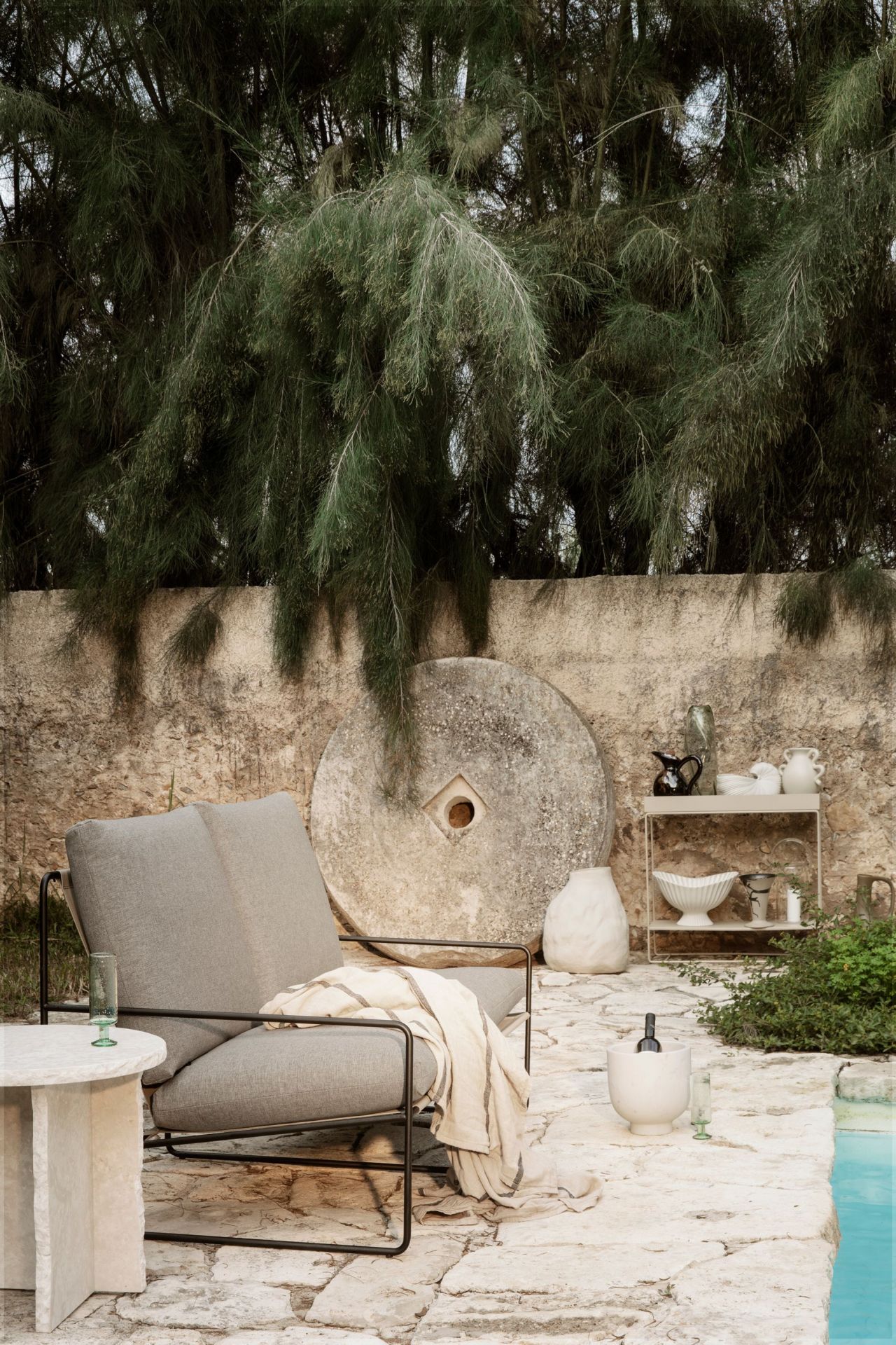 Desert 2-Sitzer Sofa von Ferm Living mit schwarzem Gestell im Outdoor-Bereich.