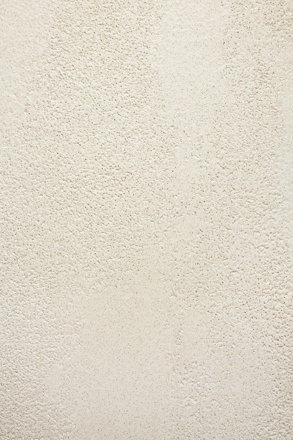 Detailaufnahme der Microcement-Oberfläche des Ethnicraft Couchtischs in Off White. Strukturierter, rechteckiger Tisch für Wohnzimmer.