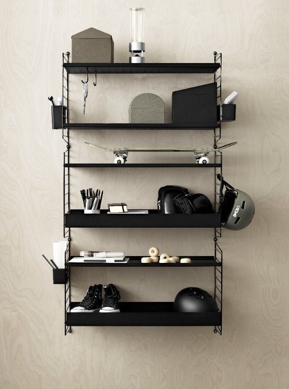 Schwarzes String Regal mit niedriger Kante (58 cm) aus Metall, befüllt mit Gegenständen.