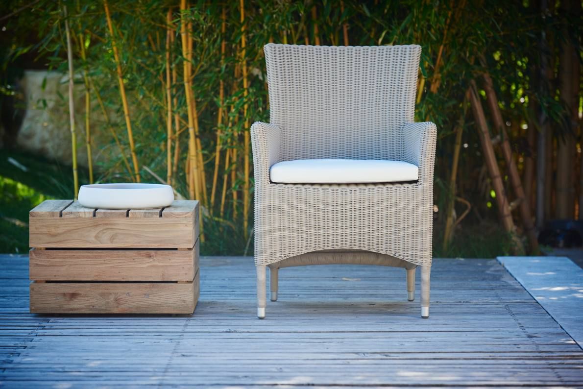 Weißer Poesie Sessel von Jan Kurtz für den Outdoor-Bereich mit Sitzkissen und Holzhocker.