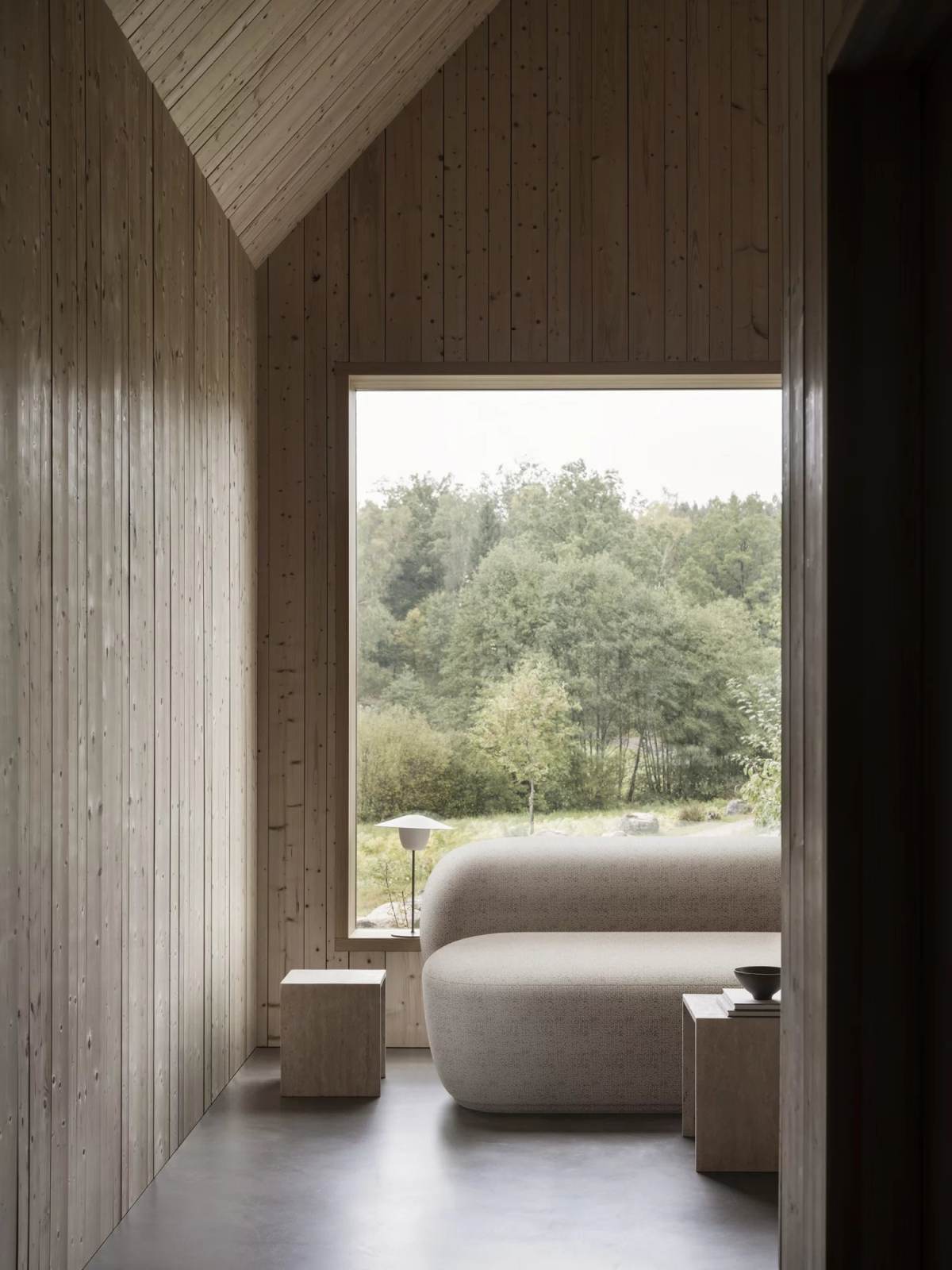 Varu Beistelltisch 2er-Set von Blomus in Tundra Gray neben einem Sofa in einem hellen Raum.