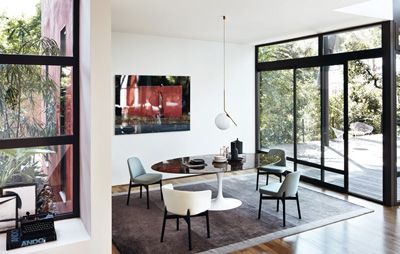 Heller Raum mit ovalem Tisch und Stühlen, darunter ein Kollektion 016 Lounge Stuhl von Knoll.