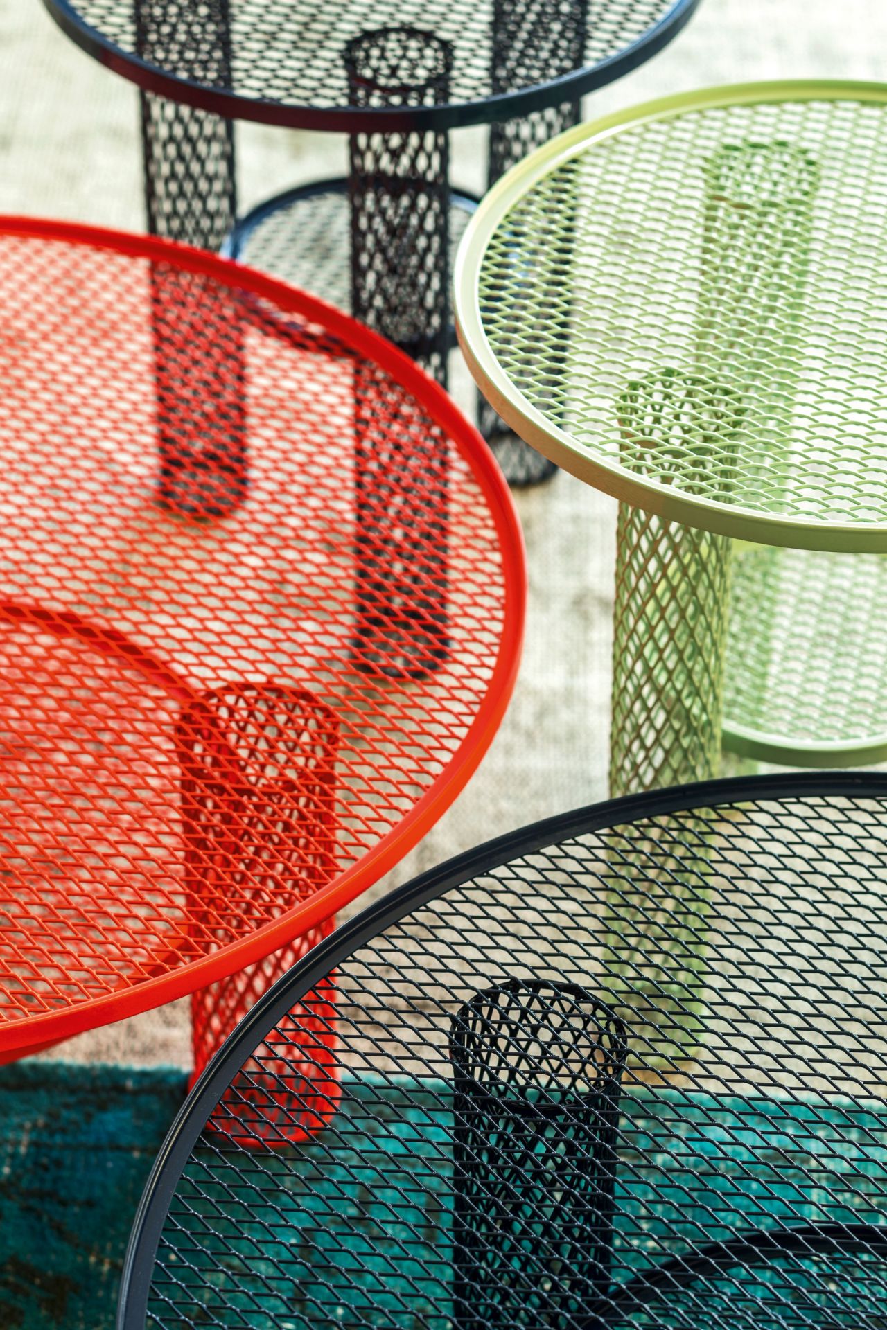 Nahaufnahme von mehreren farbigen Net Beistelltischen mit Flechtmuster von Moroso.