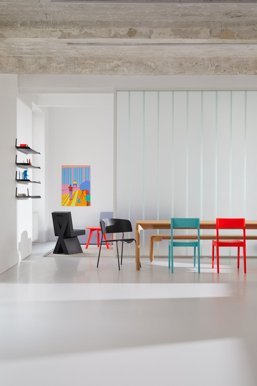 Heller Raum mit großem, gewachsten Eichentisch, passender Bank und farbigen Stühlen. Wedekind Tisch.