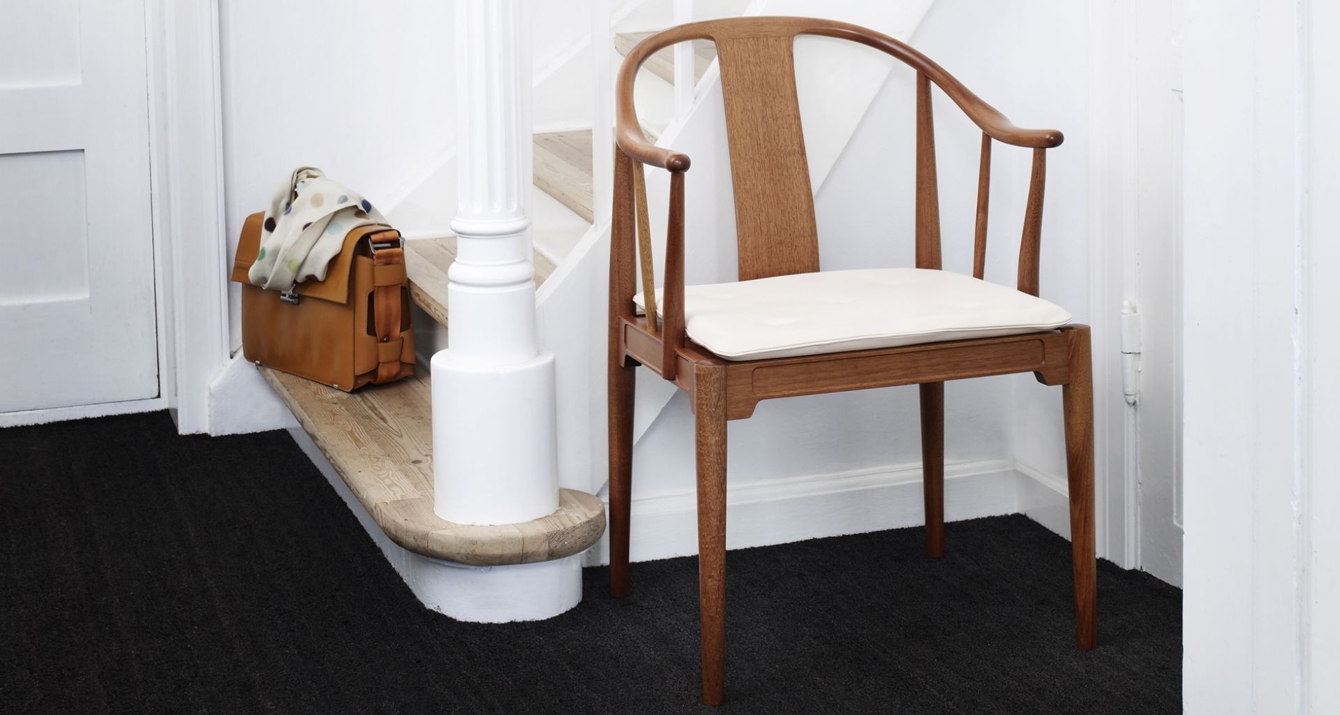 China Chair Stuhl von Fritz Hansen aus Holz mit weißem Sitzkissen im Flur.