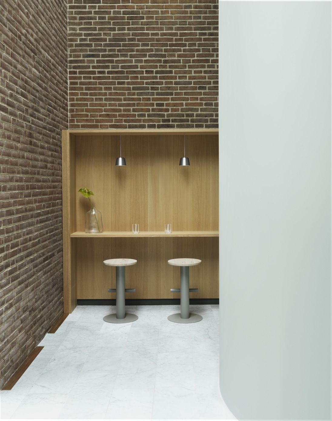 Zwei Pole Barstools von Normann Copenhagen vor einer Holzwand mit Bar-Atmosphäre.