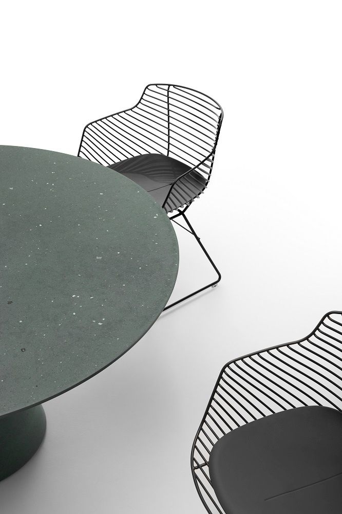 Nahaufnahme von Flow Filo Stühlen mit schwarzen Sitzkissen und einem runden Tisch.