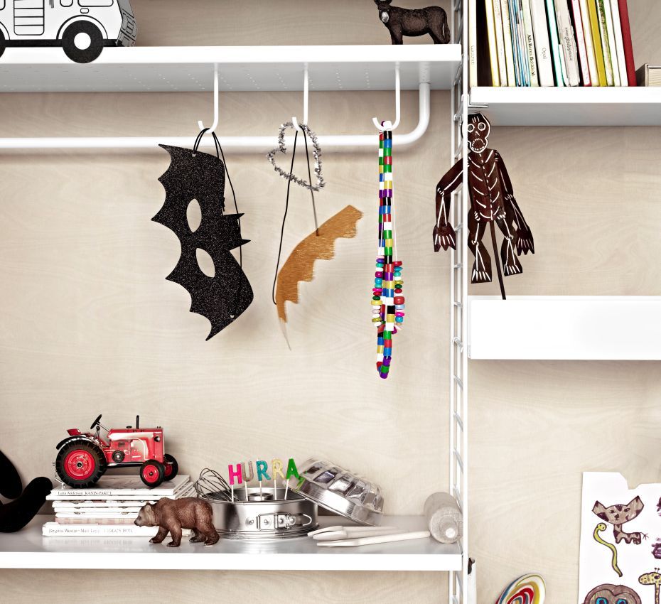 Detailaufnahme einer schwarzen String Furniture Metallregal Stange (78 cm) mit Kinderzimmer-Dekorationen.