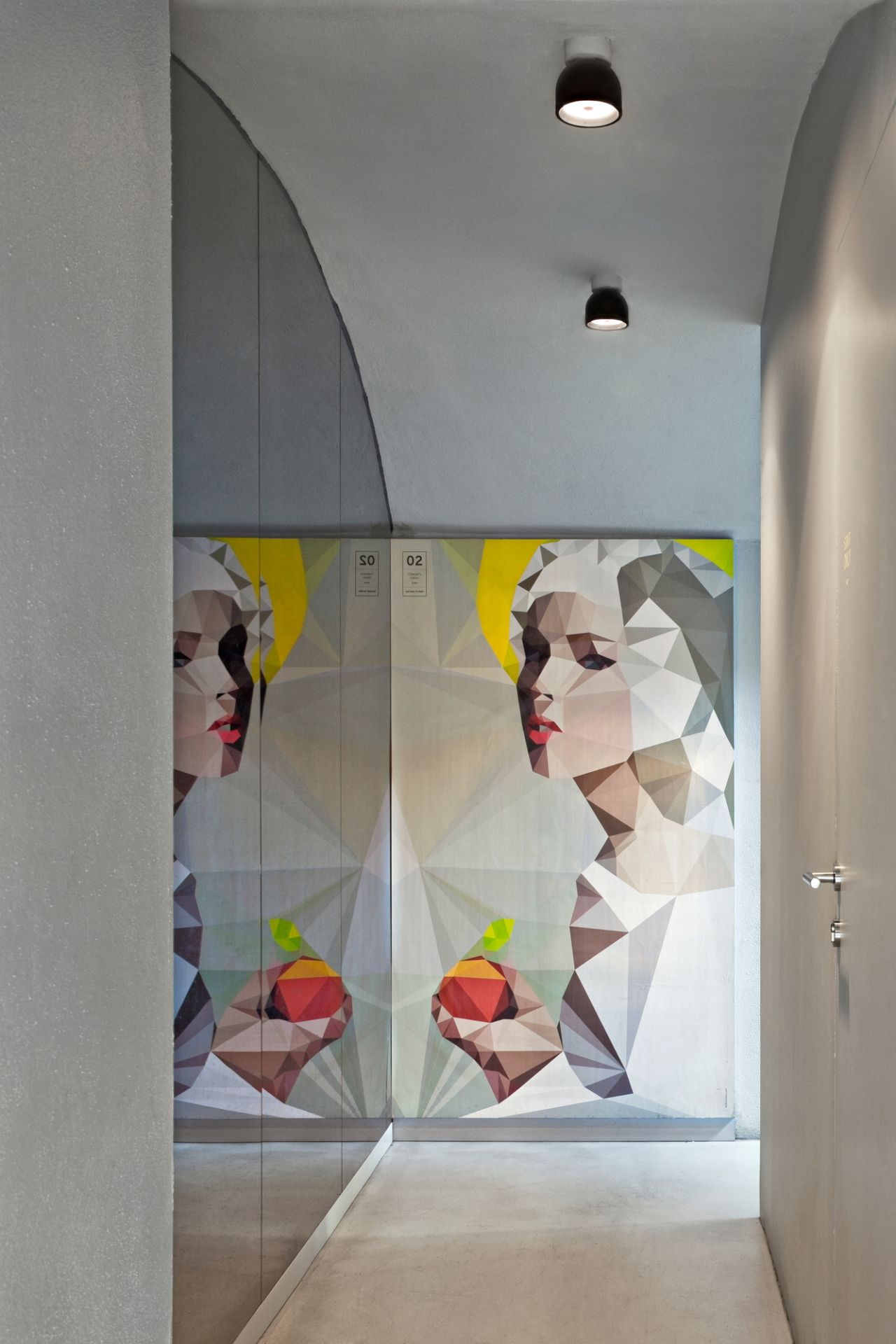 Flur mit zwei schwarzen Wan C/W Deckenleuchten von Flos und einem großen Kunstwerk an der Wand.