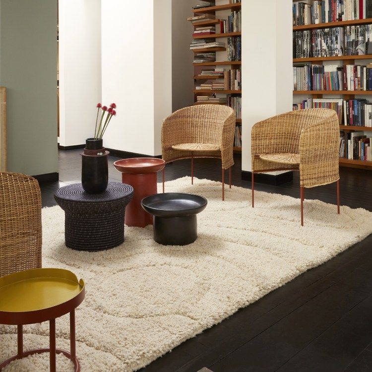 Caribe Natural Lounge Chair: Outdoor Sessel aus Rattan mit Beistelltischen auf Teppich.