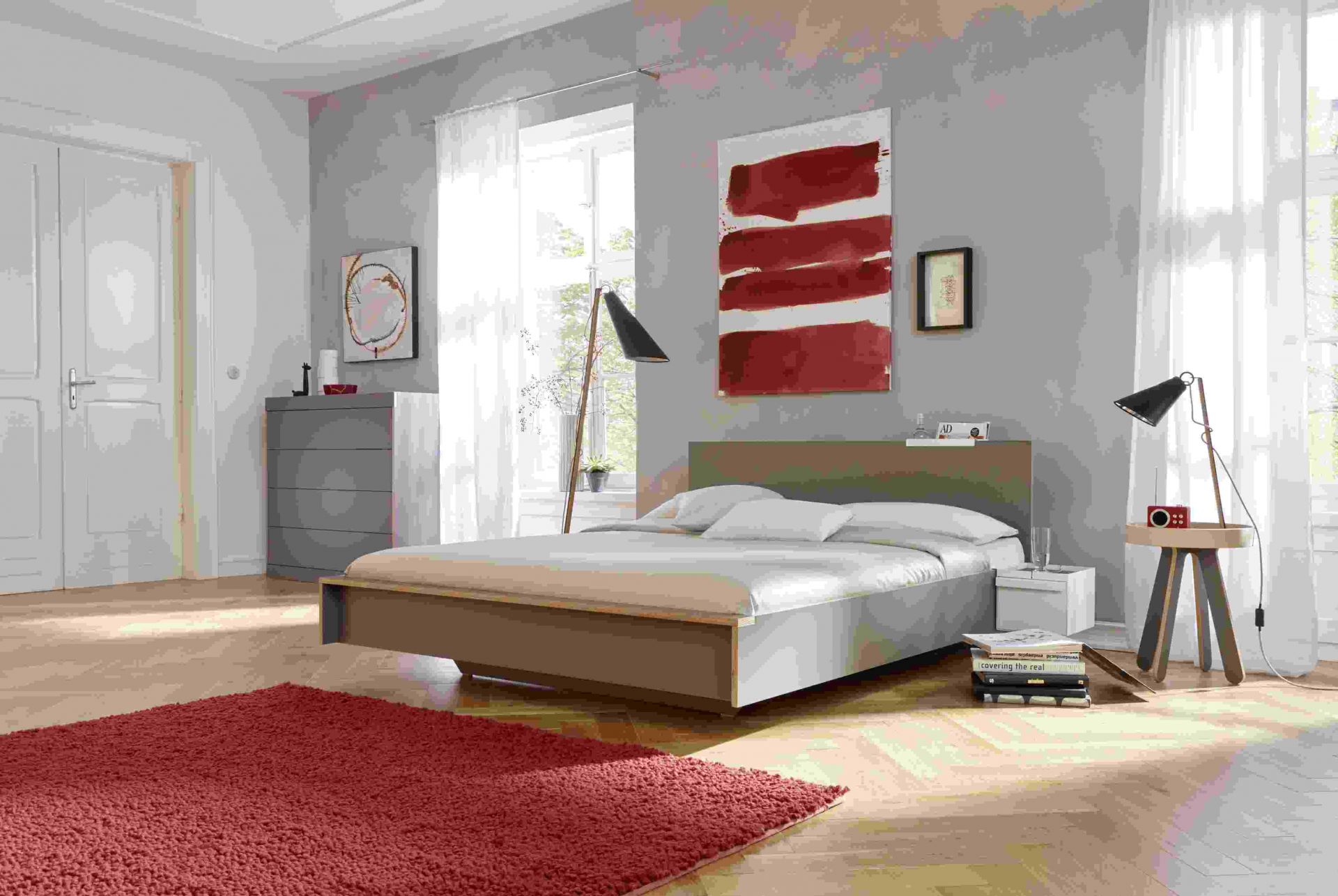 Helles Schlafzimmer mit Flai Bett von Müller Möbelwerkstätten und weißem Kopfteil.