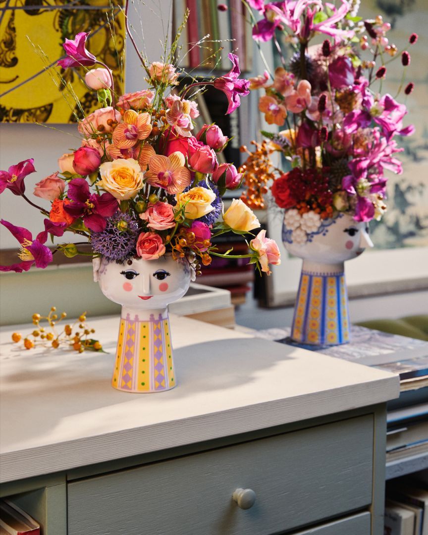 Nahaufnahme der hellblauen Eva Vase von Bjørn Wiinblad mit bunten Blumenarrangements.