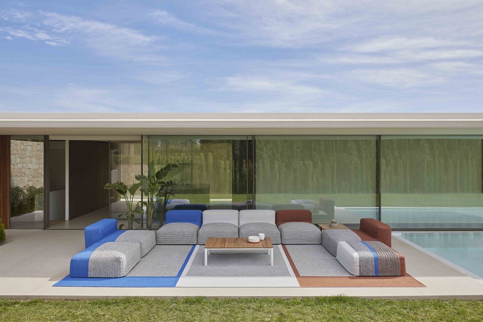 Mangas Outdoor Rug Teppich: Moderner Outdoor-Teppich mit modularem Sofa und Couchtisch auf Terrasse.