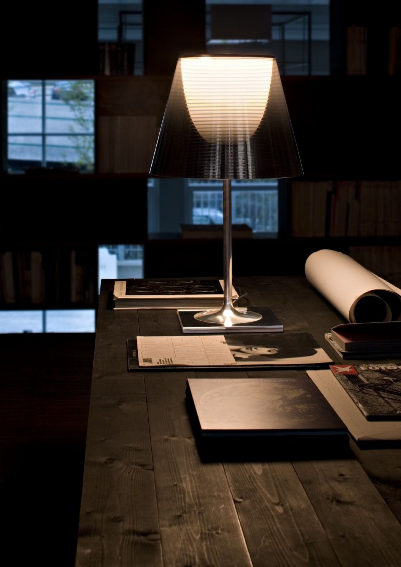 Ktribe T2 Tischleuchte von Flos auf einem Schreibtisch, modernes Design, stimmungsvolle Beleuchtung.
