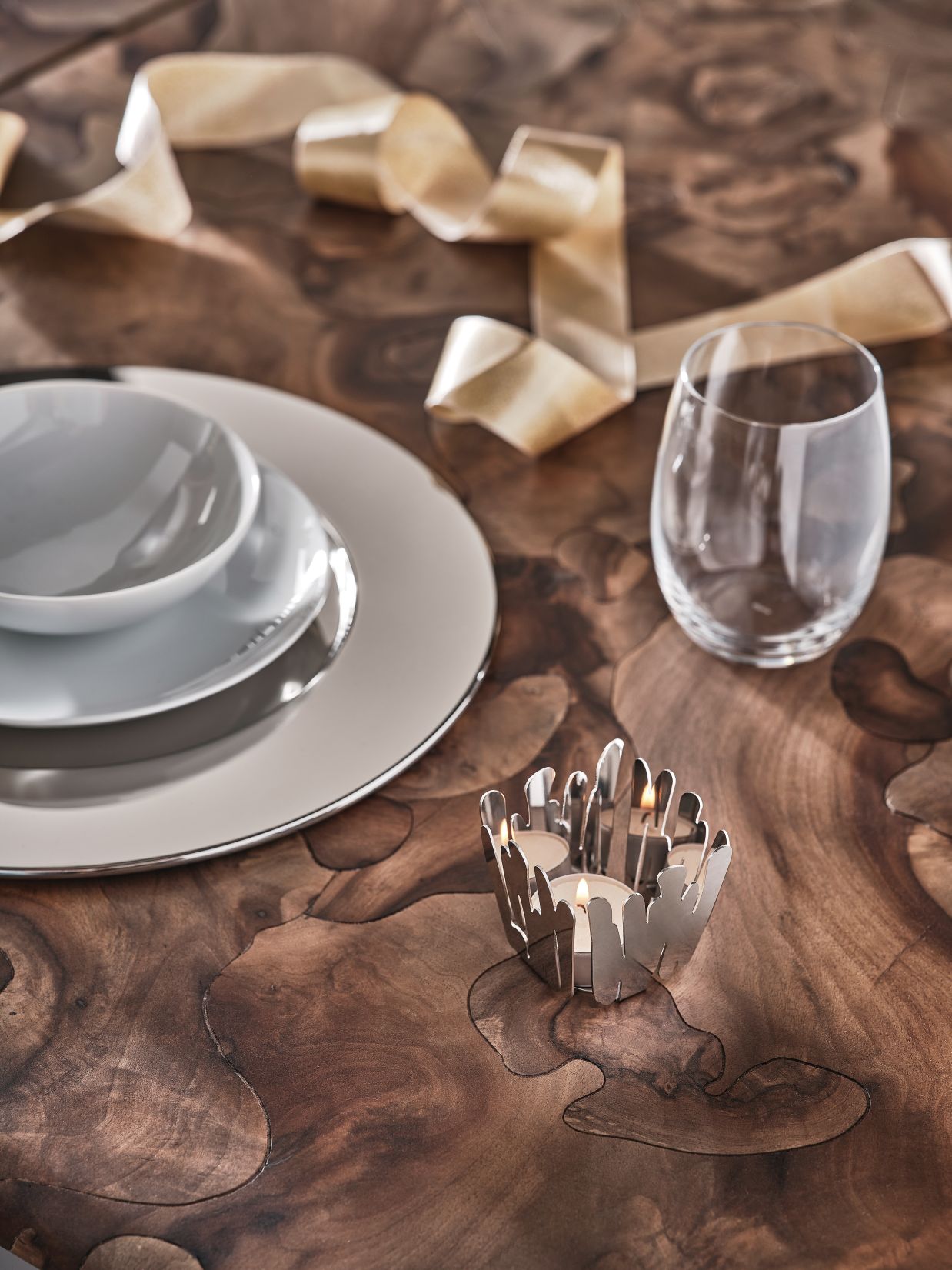 Alessi Barkandle BM19 Teelichthalter Sonderedition auf Holztisch mit Geschirr und Glas, stimmungsvolle Tischdekoration.