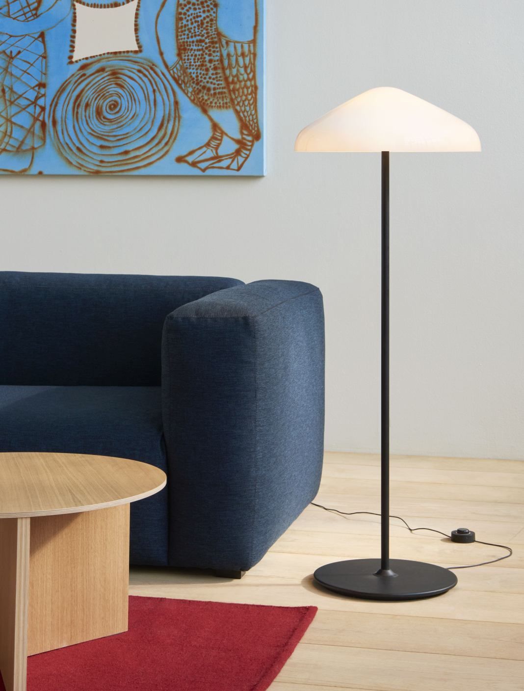 Mags Soft Sofa, ein blaues 3-Sitzer Sofa mit beigem Stich und passender Stehlampe.