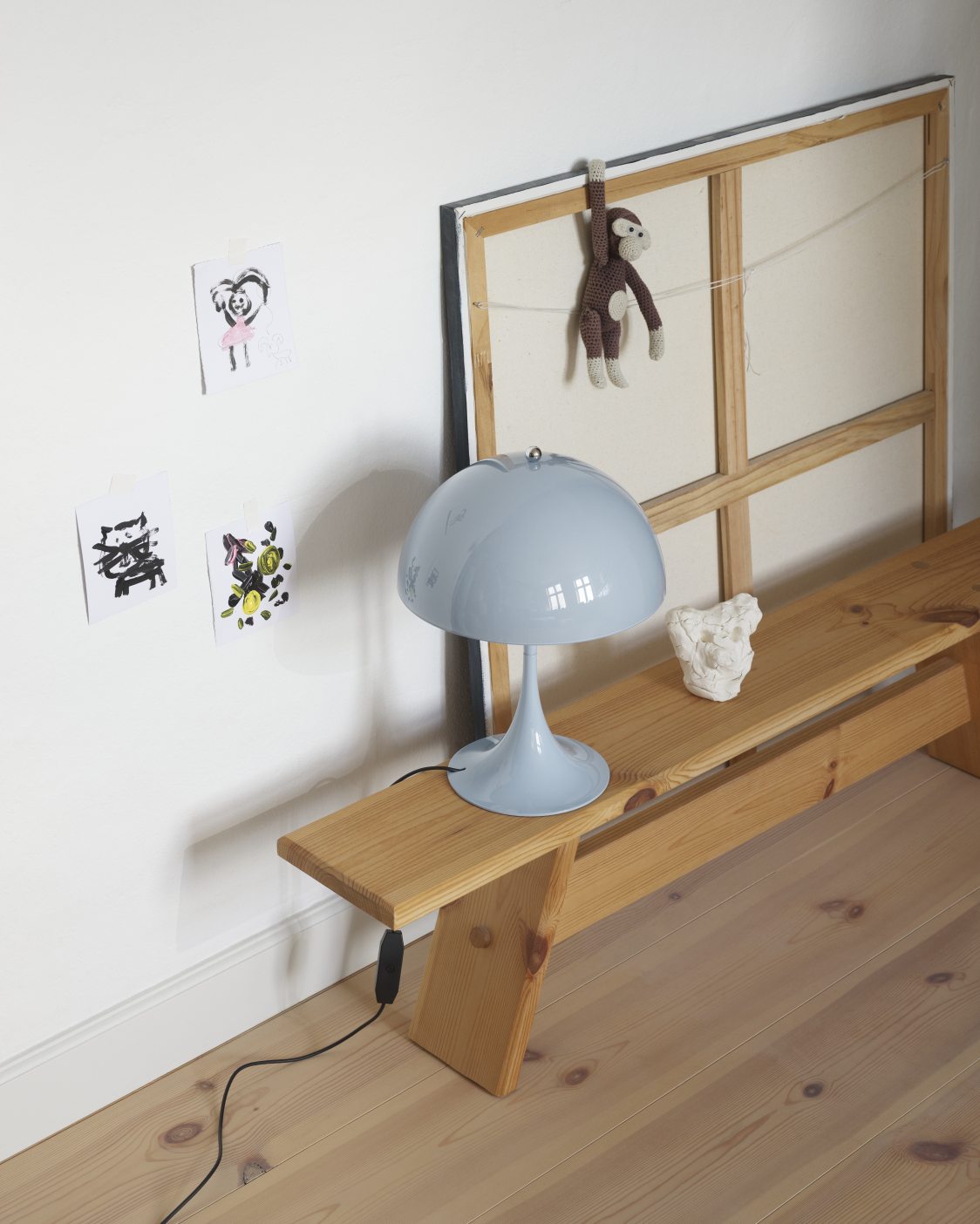 Panthella 250 Tischleuchte in Opal Pale Blau von Louis Poulsen auf einer Holzbank.