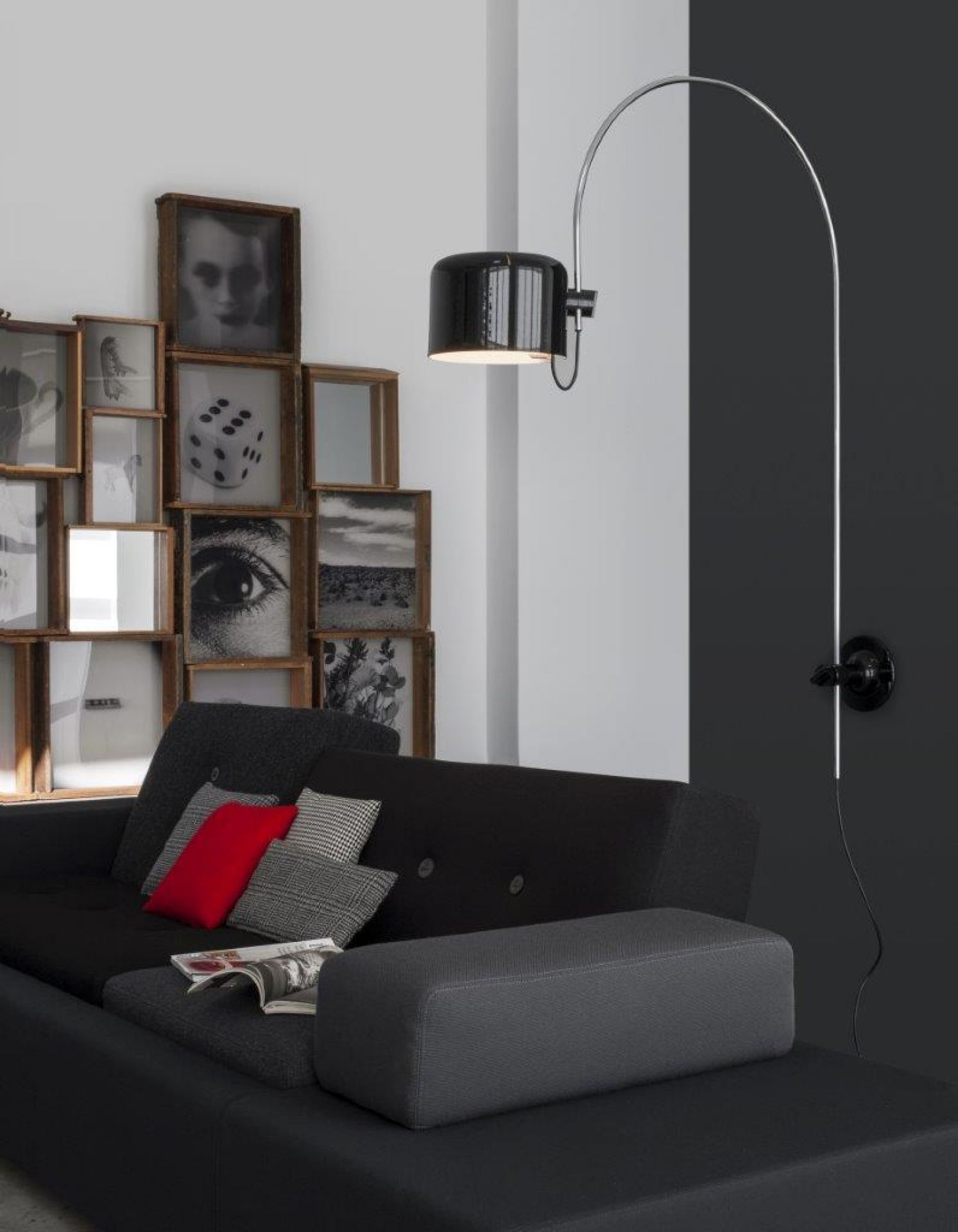 Schwarze Coupé Wandleuchte von Oluce über Sofa. Moderne Innenraumbeleuchtung für Wohnzimmer und Schlafzimmer.