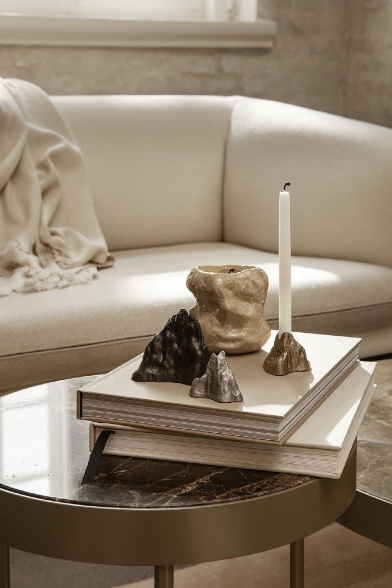 Nahaufnahme des Ferm Living Marble Table Beistelltisches mit Deko-Elementen auf Büchern.