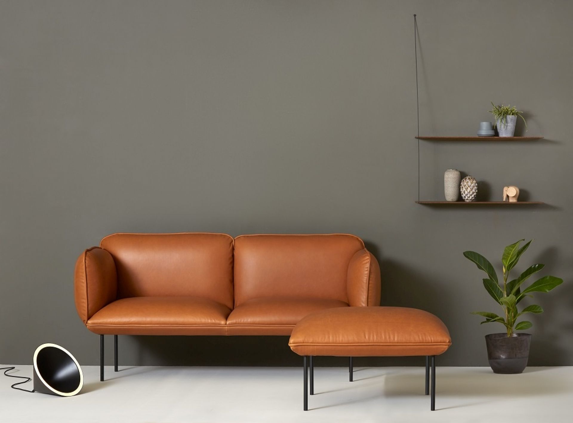 Nakki 2-Sitzer Sofa in braunem Leder mit passendem Hocker und minimalistischem Design.