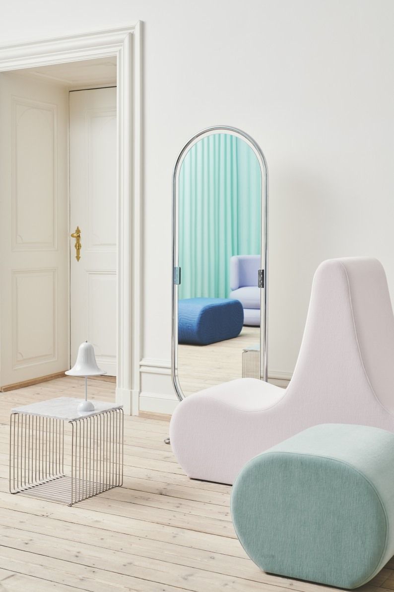 Helles Interieur mit Verpan Welle Sofa in Rosa, mintfarbenem Hocker, Spiegel und Beistelltisch auf hellem Holzboden.