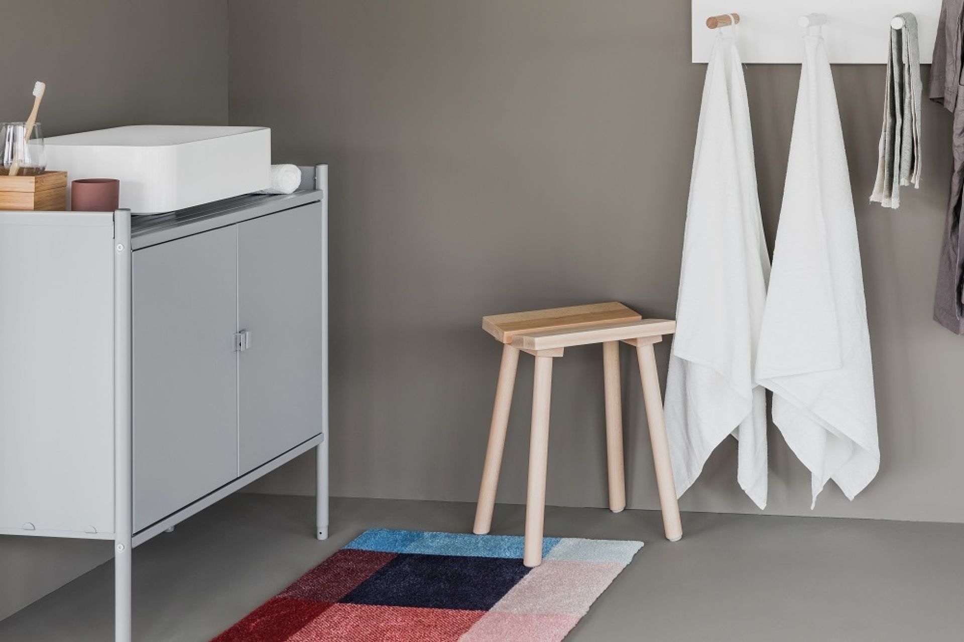 Heymat Fußmatte "Mix" im Badezimmer mit Hocker und grauen Möbeln. Indoor/Outdoor Matte.