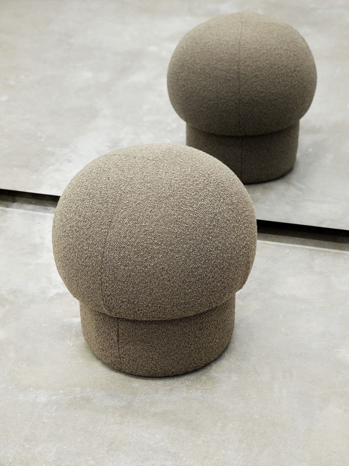 Nahaufnahme: Zwei Uno Pouf Hocker in Grün von Design House Stockholm auf hellem Untergrund.