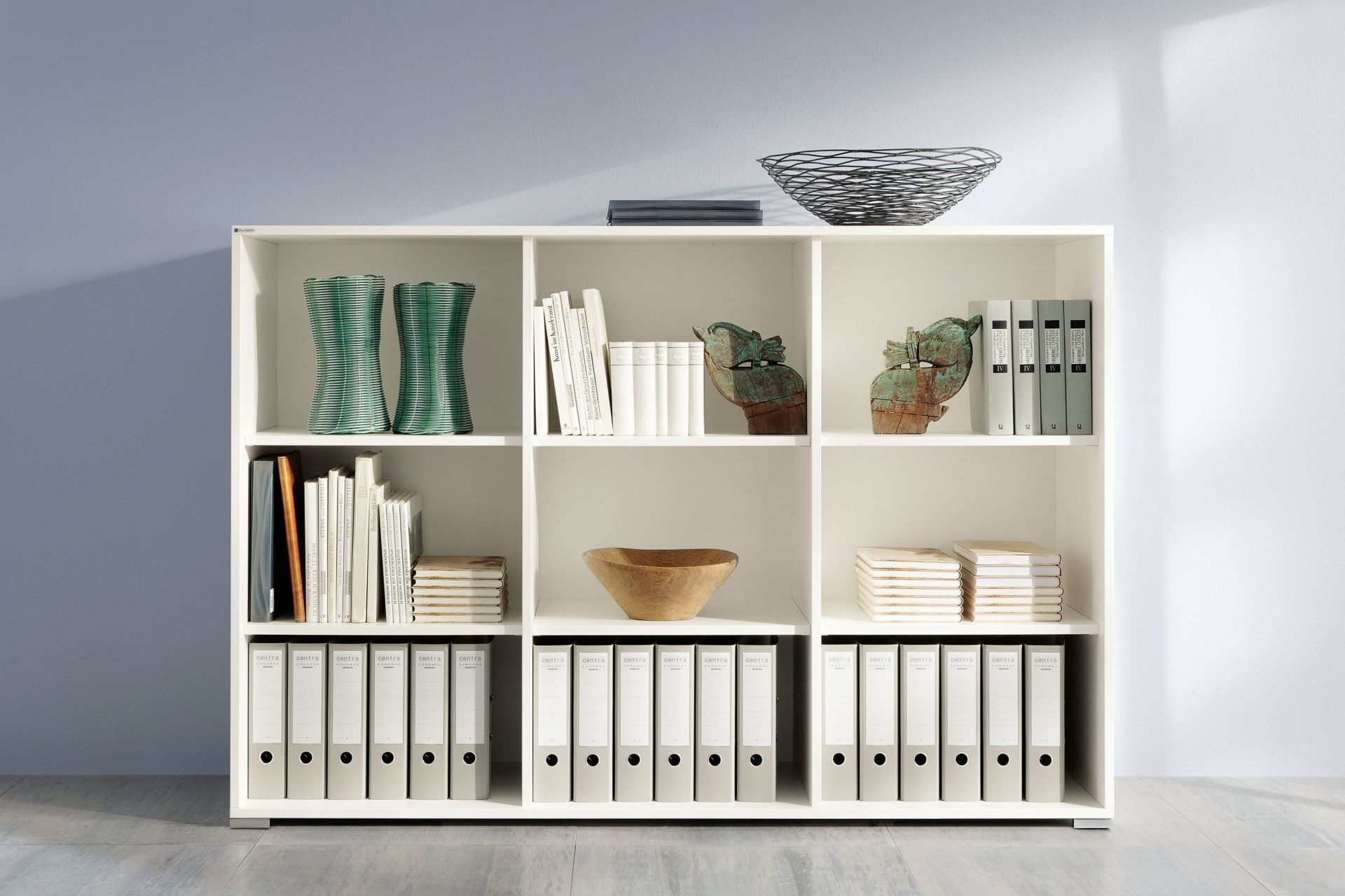 Weißer Palmberg Select Drehtürenschrank mit Ordnern, Büchern und Deko-Objekten. Büromöbel für Stauraum und Ordnung.