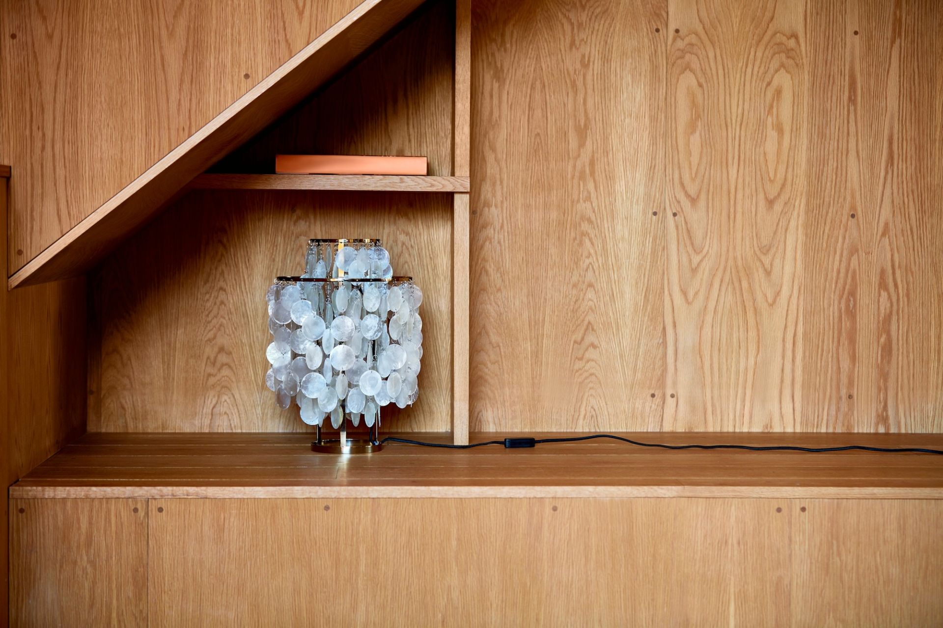 FUN 2TM Tischleuchte von Verpan mit Messingfuß und Muscheldekor im Holzregal.