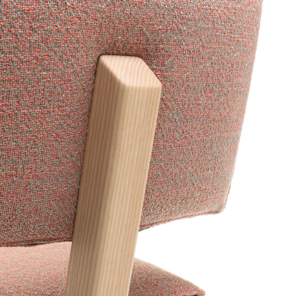 Detailaufnahme des Trave Stuhls von Magis: Holzbein und orangefarbener Stoffbezug des Designerstuhls.