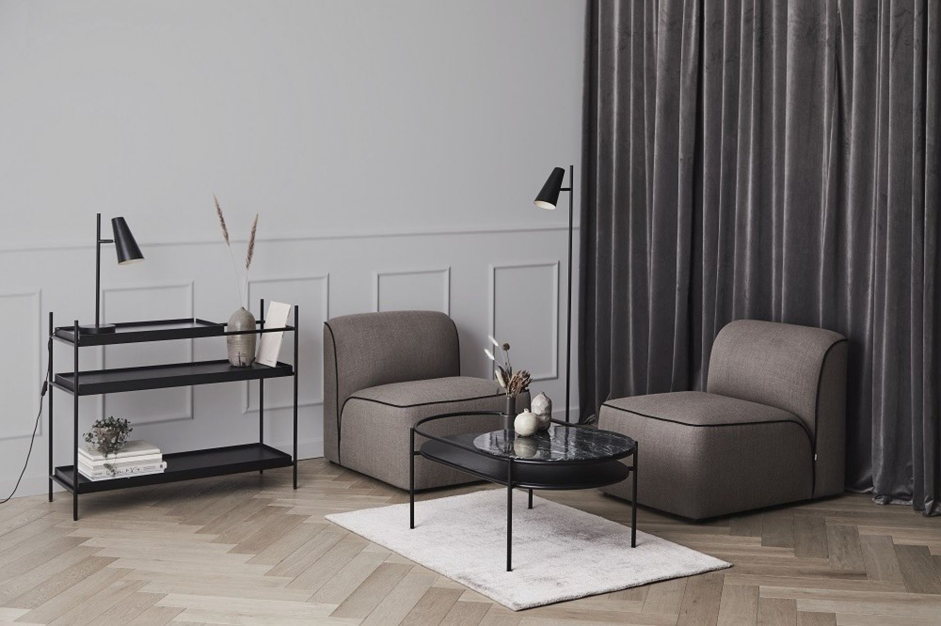 Wohnzimmer mit Cono Stehleuchte von Woud, Sesseln, Couchtisch und Regal in modernem Design.