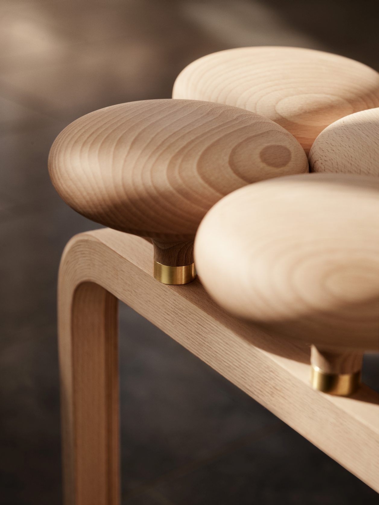 Detailaufnahme des Utzon Stool Hockers von Fritz Hansen, gefertigt aus hellem Holz mit goldenen Akzenten.