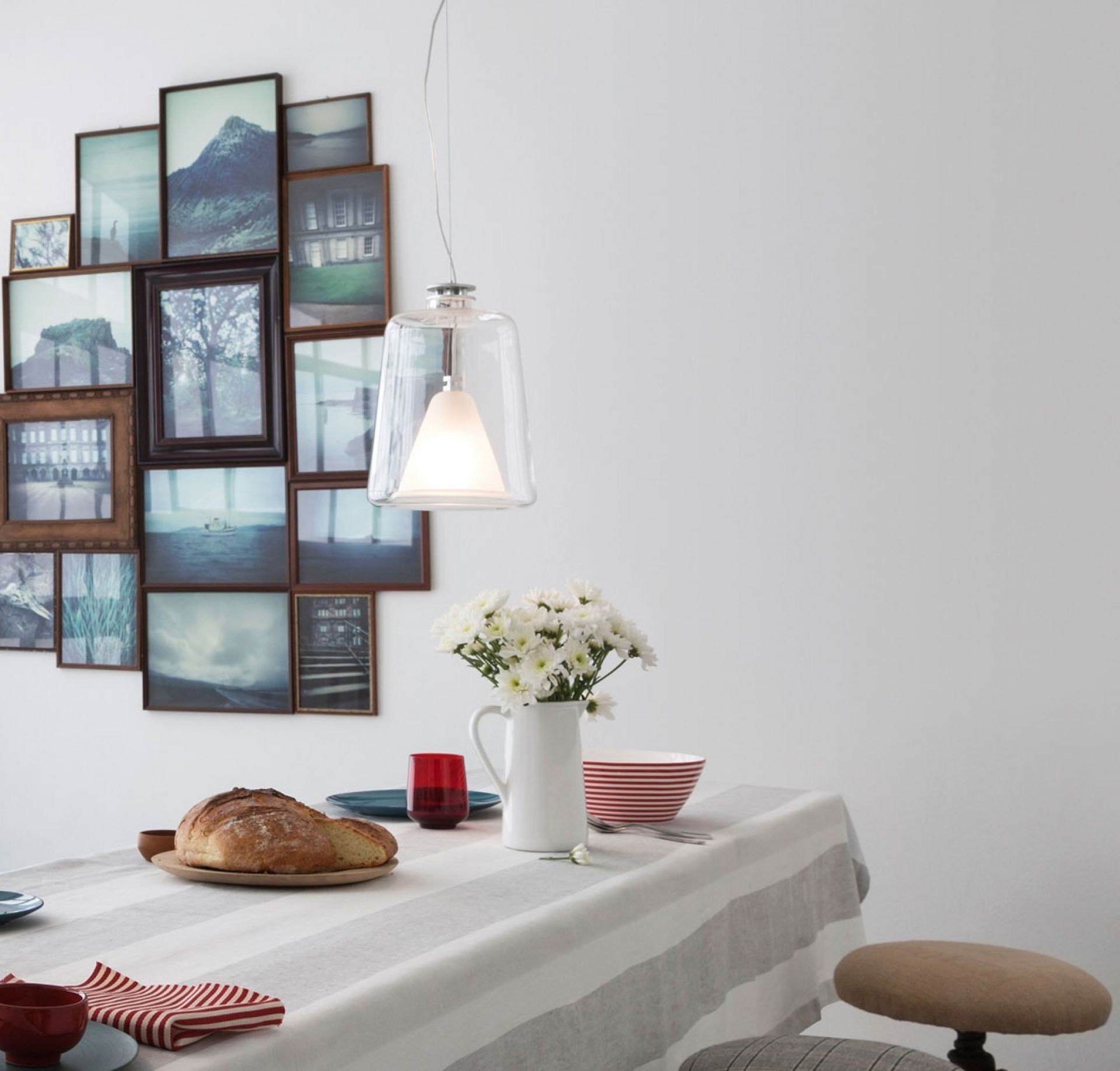 Lanternina Hängeleuchte von Oluce über Esstisch mit Brot und Blumen. Moderne Pendelleuchte.