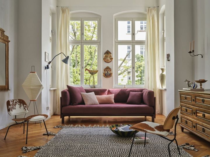 Wohnzimmer mit rotem Sofa und Designmöbeln, darunter ein Anagram Panel. Vitra Möbel.