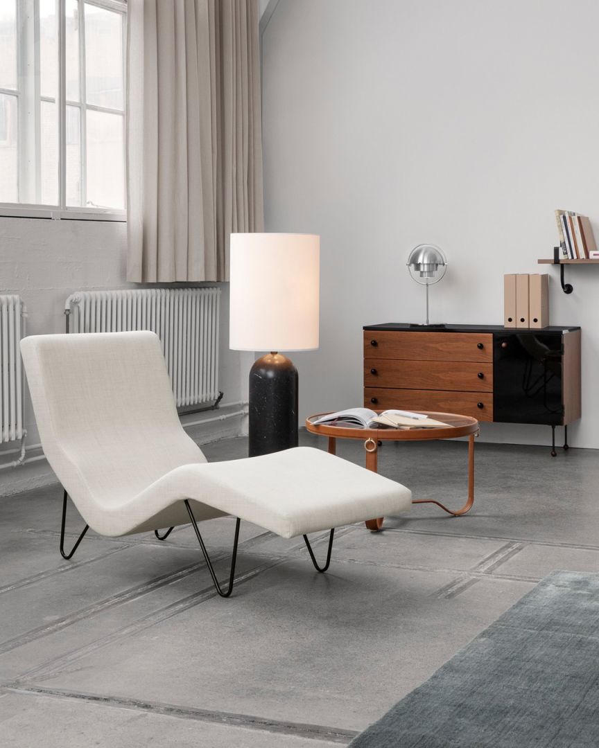 Detailaufnahme: Runder Gubi Couchtisch "Adnet Coffee Table" aus Holz mit Buch, im Wohnzimmer.