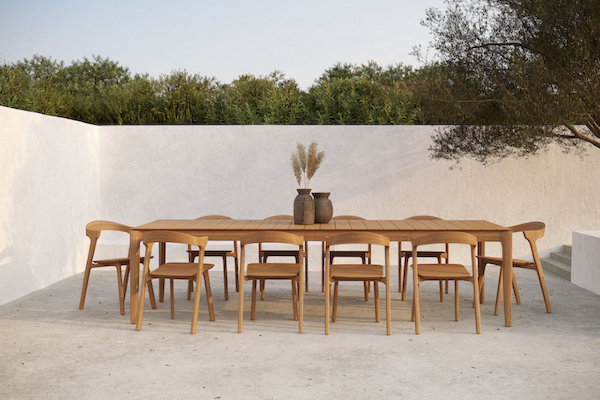 Bok Outdoor Stuhl aus Teakholz von Ethnicraft an einem Esstisch im Freien.