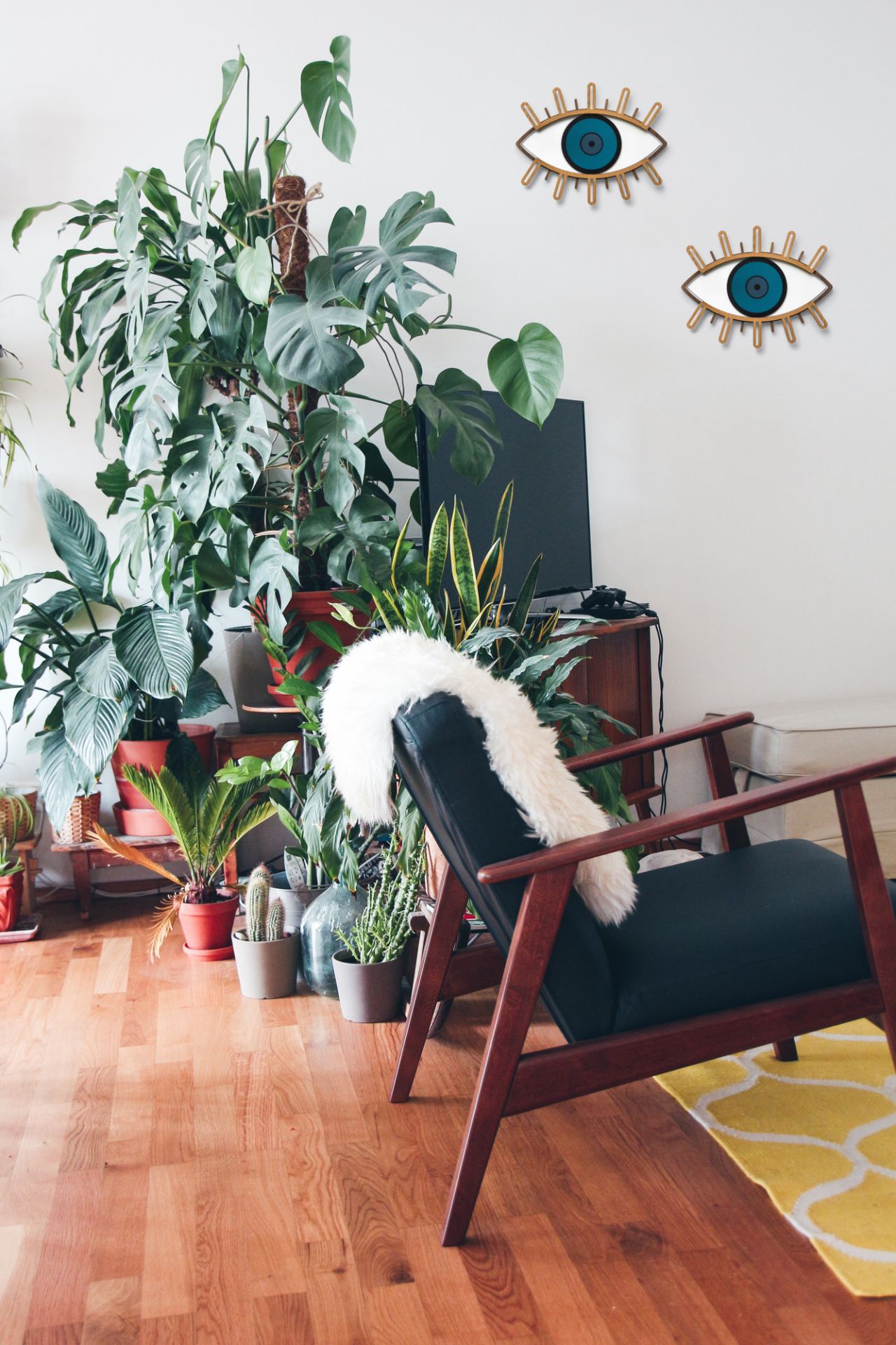 Zwei Eye 5 Auge Wandschmuck Stücke an einer weißen Wand in einem Wohnzimmer.