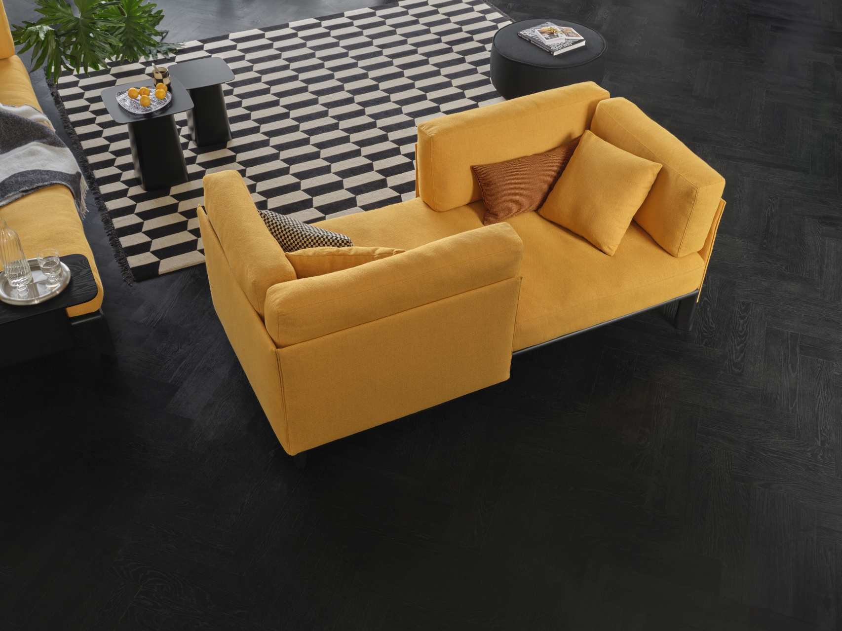 Gelbes Anagram Sofa von Vitra, 90x180 cm, mit Kissen auf dunklem Holzboden und Teppich.