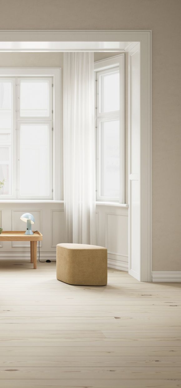 Madison Pouf Hocker in Phantom Grau im hellen Raum mit Holzboden.